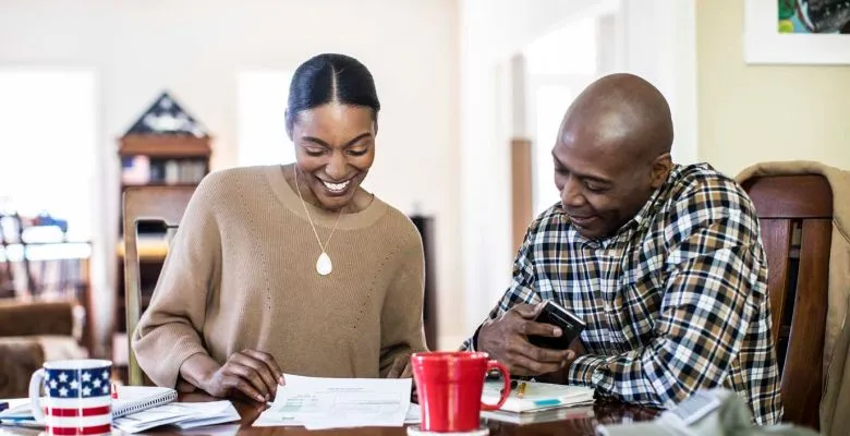 A couple sitting at a table looking at papers