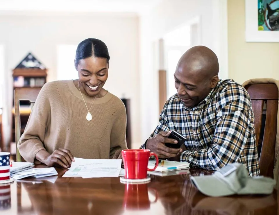 A couple sitting at a table looking at papers
