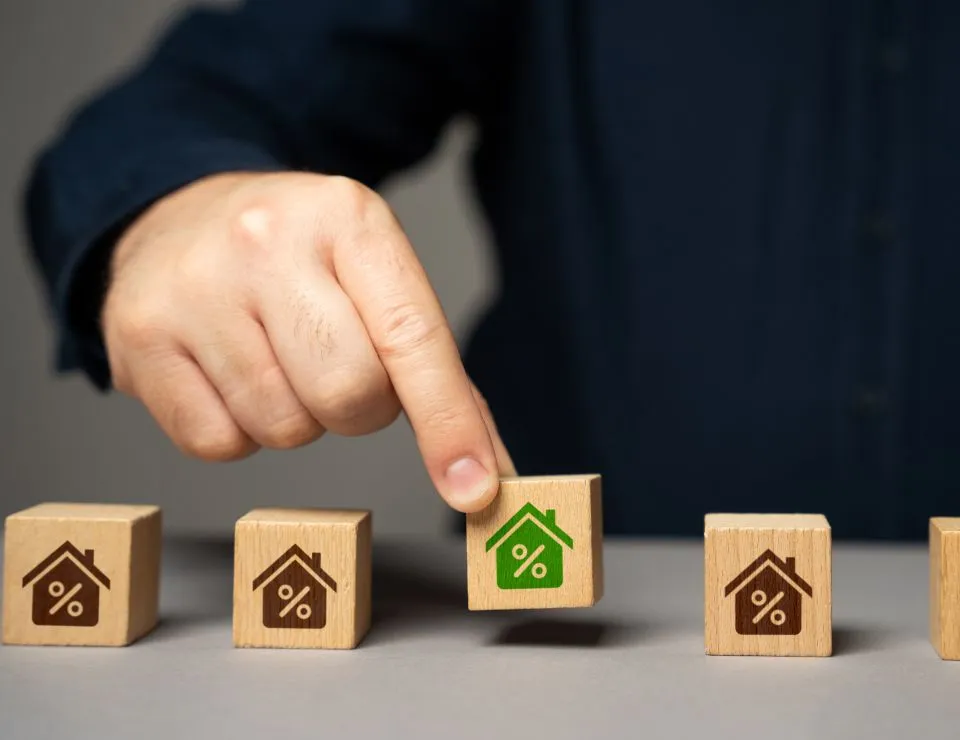 A hand choosing blocks with houses printed on them.